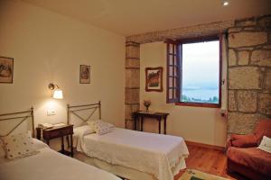 ein Schlafzimmer mit zwei Betten und einem Fenster in der Unterkunft A Bouza in Samieira