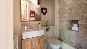 ein Badezimmer mit Waschbecken, Toilette und Spiegel in der Unterkunft Camside, Chipping Campden - Taswell Retreats in Chipping Campden + 21 Fotos