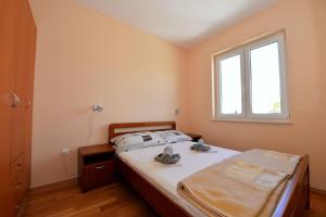 a bedroom with a bed and a window at Apartment Nadica in Novalja