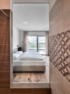 a bedroom with a large bed and a large window at Pitla Cuna Eco Relais in Terlano