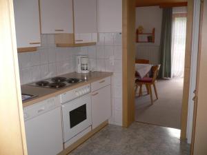 een keuken met witte kasten en een fornuis met oven bij Apartment Ilishof in Schruns