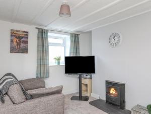 sala de estar con TV y chimenea en Oscar's Pad, en Llanfairpwllgwyngyll