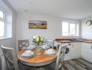 eine Küche und ein Esszimmer mit einem Tisch und Stühlen in der Unterkunft Oscar's Pad in Llanfairpwllgwyngyll