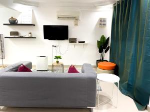 sala de estar con sofá y TV en Mas Homestay en Kuala Lumpur
