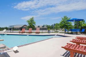 a pool with chairs and tables in it at Microtel Inn & Suites by Wyndham Gardendale in Gardendale