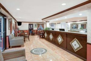 un restaurante con un bar con mesas y sillas en Howard Johnson by Wyndham Ft. Myers FL, en Fort Myers