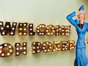 a display of lights with a woman standing next to a wall at ibis Styles Nice Aéroport Arenas in Nice