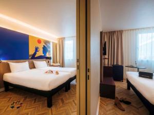 a hotel room with two beds and a room with at ibis Styles Nice Aéroport Arenas in Nice