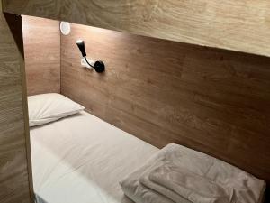 a bed with a headboard with a lamp on it at SHELTERZ Электрозаводская in Moscow