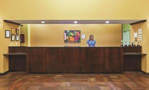 a woman standing at a reception counter in a hotel room at La Quinta by Wyndham Eastland in Eastland
