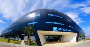 Wyndham Quito Airport في تابابيلا: مبنى ازرق امامه نخله
