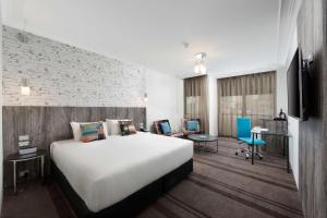a hotel room with a large bed and a desk at Rydges Sydney Central in Sydney
