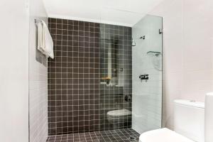 a bathroom with a shower and a toilet at Rydges Sydney Central in Sydney