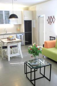 a kitchen and living room with a table and a green couch at 2 bedrooms house with terrace at Nazare 1 km away from the beach in Nazaré