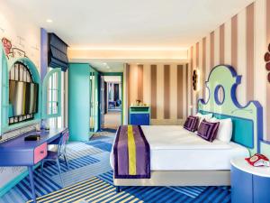 a bedroom with a large bed and a desk at The Land Of Legends Kingdom Hotel - All-in Concept in Belek