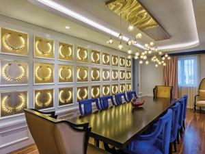 a conference room with a long table and blue chairs at The Land Of Legends Kingdom Hotel - All-in Concept in Belek