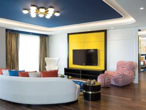 a living room with a couch and a tv at The Land Of Legends Kingdom Hotel - All-in Concept in Belek