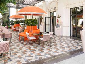 an outdoor patio with chairs and tables and an umbrella at The Land Of Legends Kingdom Hotel - All-in Concept in Belek