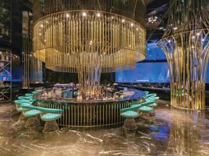 a dining room with a large chandelier and green chairs at The Land Of Legends Kingdom Hotel - All-in Concept in Belek