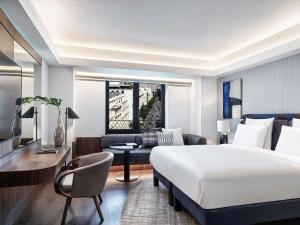 una camera d'albergo con letto e scrivania di Athens Capital Center Hotel - MGallery Collection ad Atene