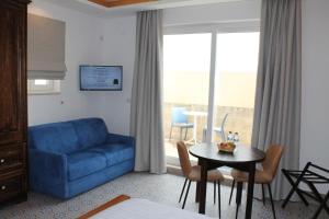 a living room with a blue couch and a table at Palazzino Nina Boutique Hotel in Qormi