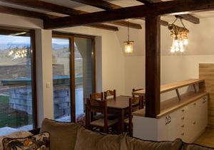 una cucina e una sala da pranzo con tavolo e sedie di Villa Piece of Soul Zabljak a Žabljak