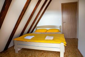 un letto con lenzuola gialle e due asciugamani sopra di Villa Piece of Soul Zabljak a Žabljak