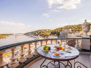 a breakfast table on a balcony with a view of the river at Fairmont Grand Hotel Kyiv in Kyiv
