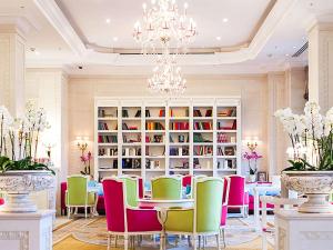 a dining room with colorful chairs and a chandelier at Fairmont Grand Hotel Kyiv in Kyiv