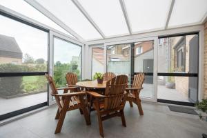 a dining room with a table and chairs and windows at Huize Porteman in Staden