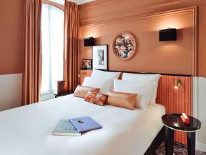 una habitación de hotel con una cama con un libro encima en Mercure Paris Gare De Lyon Opera Bastille, en París