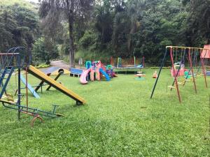 a bunch of playground equipment in the grass at LOFT EM PETRÓPOLIS - ITAIPAVA in Petrópolis