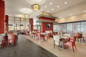 un comedor con mesas, sillas y ventanas en Ramada Plaza by Wyndham Eskisehir, en Eskisehir