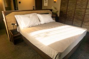 un grande letto con lenzuola e cuscini bianchi di Agriturismo Terra del Sole ad Albosaggia