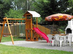 a playground with a red slide and an umbrella at Pension U Milana in Dvůr Králové nad Labem