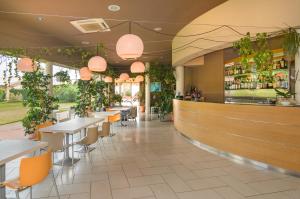 a restaurant with tables and chairs and plants at Residence San Rossore in Pisa