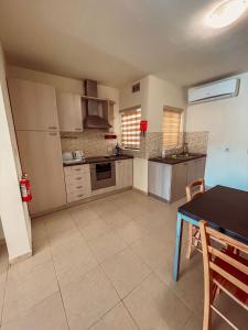 una grande cucina con tavolo e tavolo di Stresa Court Apartments a San Giuliano