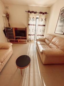 un soggiorno con divano e tavolo di Stresa Court Apartments a San Giuliano