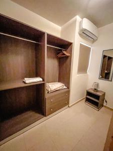 Habitación con armarios de madera y ventilador. en Stresa Court Apartments, en San Julián