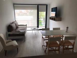 a living room with a couch and a table and chairs at Mioceno in Puerto Madryn +8 photos