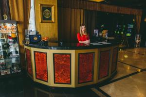 a woman standing at a counter in a bar at Altai Palace Hotel in Manzherok