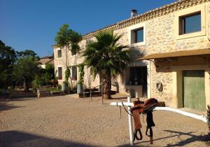 a bed in front of a stone building at Le Mas Des Brune in Saint-Laurent-dʼAigouze