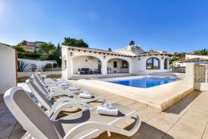 een villa met een zwembad en ligstoelen bij Villas Guzman - Erita in Benissa