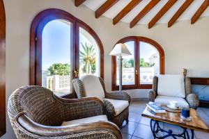 un soggiorno con mobili in vimini e ampie finestre di Villas Guzman - Erita a Benissa