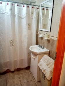 a bathroom with a sink and a white shower curtain at Monoambiente en pleno centro in Santa Fe