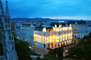 ein beleuchtetes Gebäude in einer Stadt in der Nacht in der Unterkunft Hotel Regina in Wien