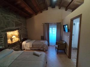 a bedroom with two beds and a television in it at Casa Do Cribeiro in Ponteareas