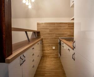 una scala in una cucina con armadi bianchi e pavimenti in legno di Villa Piece of Soul Zabljak a Žabljak Altre 36 foto