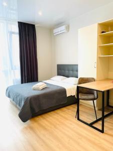 1 dormitorio con cama, mesa y escritorio en Mira Apart-Hotel en Kiev