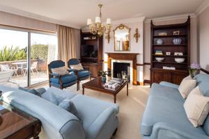 een woonkamer met blauwe meubels en een open haard bij The Atlantic Hotel - Small Luxury Hotels of the World in St Brelade